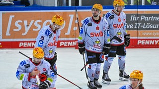 Spieler der Pinguins Bremerhaven stehen enttäuscht auf dem Eis.