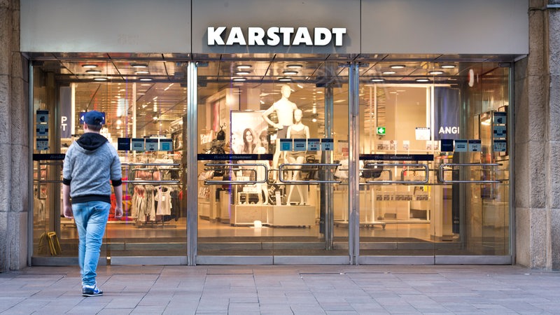 Mann geht in Karstadt Warenhaus