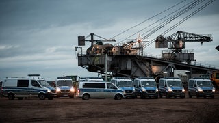 Polizeiautos stehen am Rande der Kohlegrube.