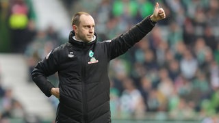 Werder-Trainer Ole Werner signalisiert seinen Spielern von der Seitenlinie aus "Daumen hoch".