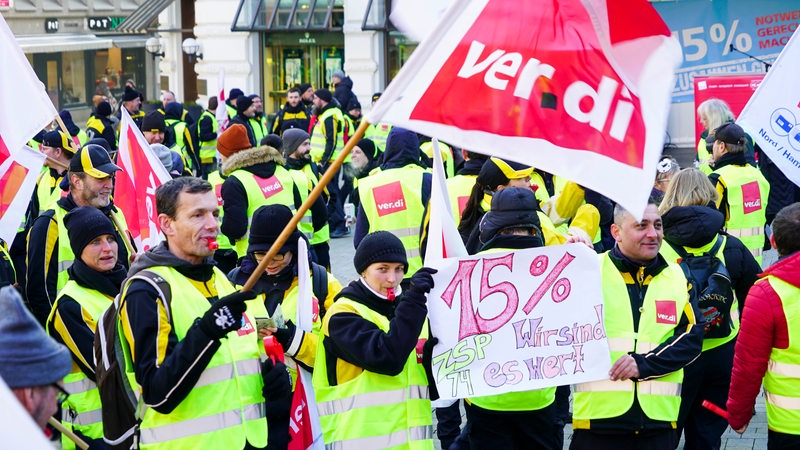 Beschäftigte der Post streiken und halten Verdi-Banner 