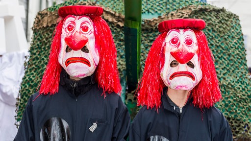 Zwei traurige Masken auf einer Fastnachtsprozession