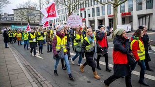 Demonstranten laufen mit Plakaten durch die Innenstadt. Im Tarifkonflikt im öffentlichen Dienst hat die Gewerkschaft Verdi erneut zu Warnstreiks aufgerufen.