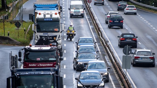 Ein Motorradfahrer fährt mit seinem Motorrad bei einem Stau auf der B75 zwischen den Autos entlang.