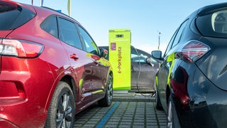 Auto steht auf E-Parkplatz mit Ladesäule