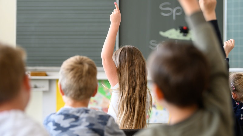 Schüler melden sich im Unterricht.