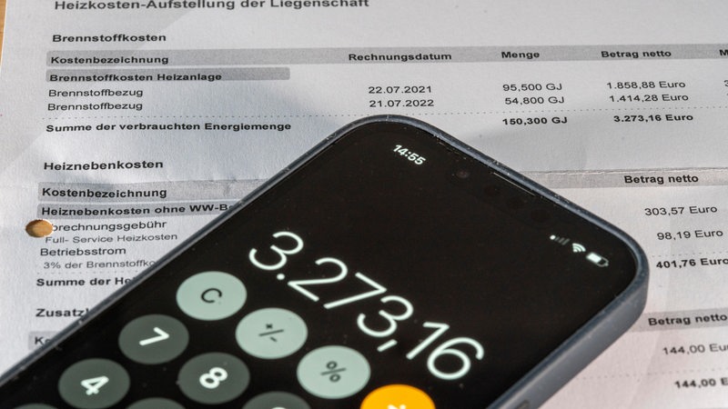 Ein Smartphone mit geöffneter Taschenrechner-App liegt auf einer Auflistung der Mietnebenkosten. Zu sehen ist die Zahl 3.273,16.