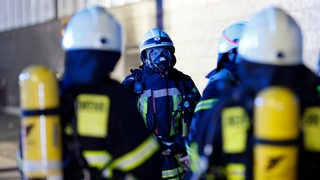 Einsatzkräfte der Feuerwehr mit Schutzanzügen