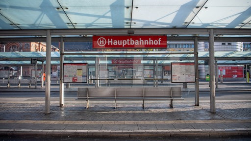 Eine Person läuft über die Gleise der Straßenbahnhaltestelle vor dem Bremer Hauptbahnhof.