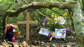 Der Fundort der Leiche des ermordeten Mädchens Adelina in einem Wald bei Leeste ist am 12.10.2001 mit einem Teddybär, Blumen und einem Holzkreuz geschmückt.