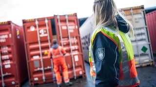 Eine Zoll-Frau vor einem Container