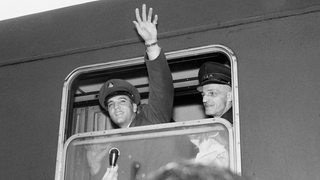 Elvis Presley winkt am 01.10.1958 auf dem Bahnhof von Bremerhaven aus einem Zugabteil.