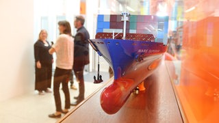 Ein Containerschiff steht in einer Vitrine.