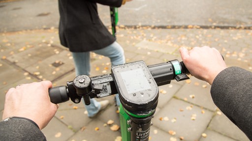 Zwei Frauen auf E-Scootern bei herbstlichem Wetter