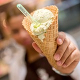 Eine Kinderhand hält ein Waffeleis in die Kamera.