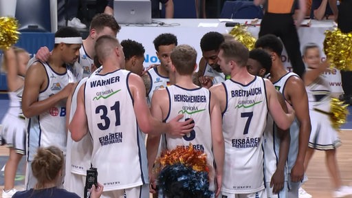 Das Team der Eisbären Bremerhaven stehen nach einem Spiel im Kreis zusammen