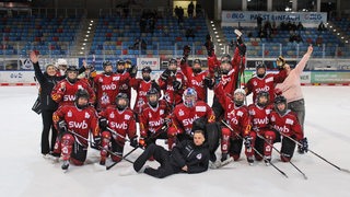 Das Eishockey-Team der Fischtown Ladies posiert in roten Trikots auf dem Eis in der Eisarena Bremerhaven für ein Mannschaftsfoto.