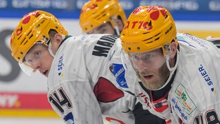 Die Eishockey-Spieler Nicholas Jensen und Ross Mauermann in Nahaufnahme auf dem Eis, sie schauen konzentriert.