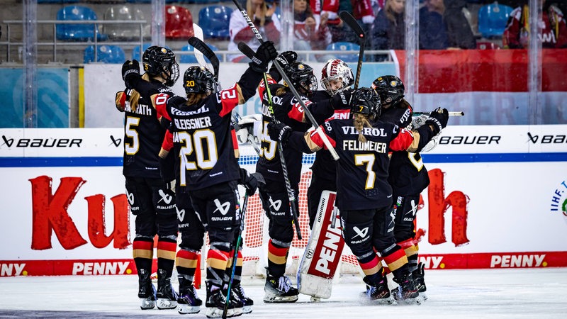 Das deutsche Frauen-Eishockey-Team jubelt gemeinsam auf dem Eis nach einem Tor.