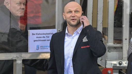 Fischtown-Manager Sebastian Furchner steht in der Eisarena Bremerhaven und telefoniert.