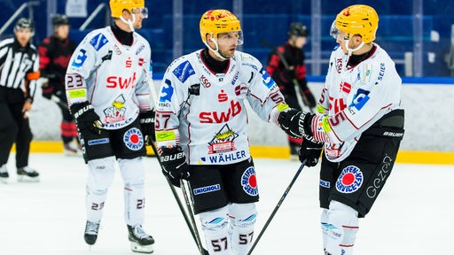 Eishockey-Spieler Alex Friesen steht bei einem Testspiel der Fischtown Pinguins mit einem Teamkollegen auf dem Eis und klatscht ab.