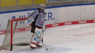 Ein Eishockey-Torhüter steht vor dem Tor.