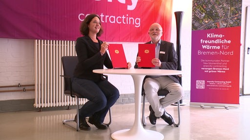 Die Senatorin Kathrin Moosdorf und Manfred Schüle von der Firma Enercity beim Unterschreiben eines Vertrages