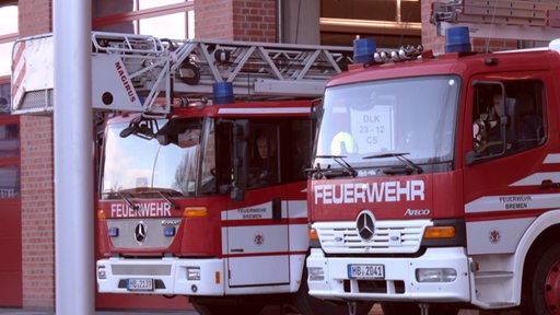 Feuerwehrautos stehen in der Garage der Feuerwehrwache.