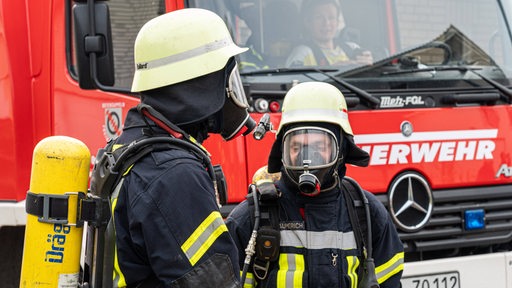 Zwei Feuerwehrmänner unter Atemschutz bei einem Feuer. 