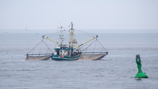 Ein Fischkutter zieht in der Deutschen Bucht nahe der Elbmündung seine Netze durch das Wasser der Nordsee.