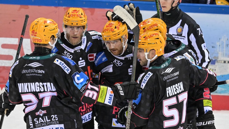 Eishockeyspieler der Fischtown Pinguins feiern ein Tor gegen die Eisbären Berlin.