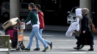 Syrische Flüchtlinge gehen in Hannover mit Gepäck zu einem Bus. (Archivbild)