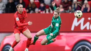 Werders Fußballerin Saskia Matheis fliegt im Zweikampf mit einer Bayern-Spielerin durch die Luft.