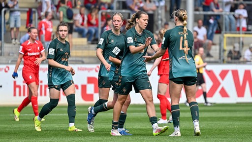 Werder-Fußballerinnen klatschen bei Mitspielerin Larissa Mühlhaus nach ihrem Tor gegen Freiburg ab.