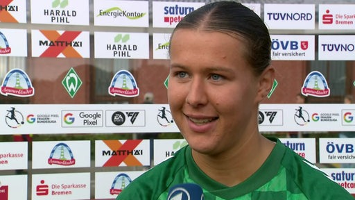 Werders Torschützin Larissa Mühlhaus strahlt nach dem Spiel gegen Potsdam vor einer Werbewand beim Interview.