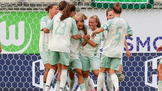 Die Fußballerinnen von Werder Bremen kommen beim Torjubel gegen Wolfsburg zusammen.