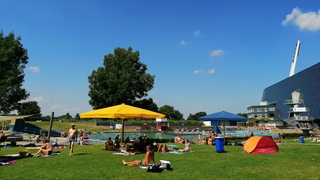 Badegäste liegen auf einer Wiese im Stadionbad