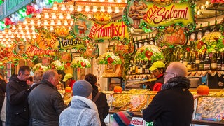 Menschen stehen vor einer Bude auf dem Freimarkt