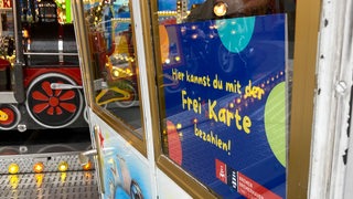 Kassenhäuschen eines Karussells zeigt, dass hier mit der Freikarte bezahlt werden kann.