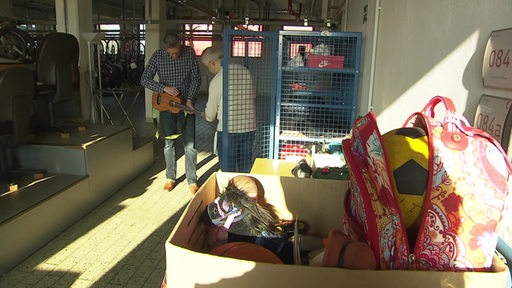 Zwei Männer im Fundbüro mit einer Ukulele