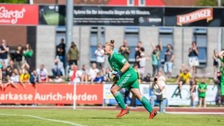 Paula Blum steht im Tor und hält einen Ball in der Hand.