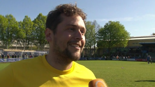 BSV-Torwart Malte Seemann steht lächelnd nach dem Spiel auf dem Platz beim Interview.