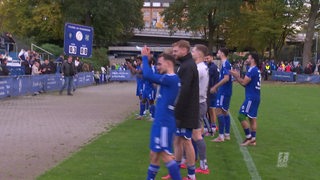 Fußballspieler des Bremer SV applaudieren nach dem Sieg vor ihrem Fanblock am Panzenberg den Fans.