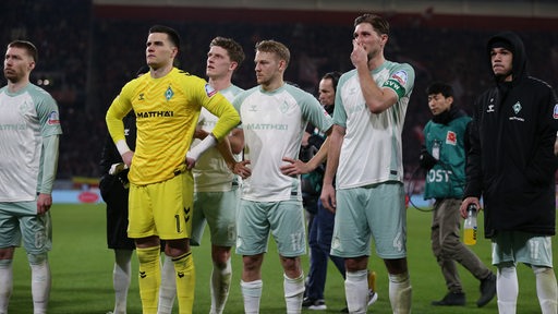 Werder-Spieler stehen nach der 0:5-Niederlage in Freiburg frustriert vor ihrem Fanblock.