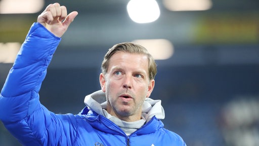 Fußball-Trainer Florian Kohfeldt von Darmstadt 98 reckt den Arm hoch in Richtung der Fans.