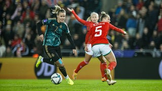 Die deutsche Fußball-Nationalspielerin Lena Petermann setzt sich gegen zwei englische Spielerinnen durch.