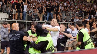 Fans von Eintracht Frankfurt prügeln sich mit Ordnern.