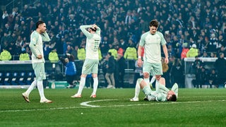 Werder-Spieler stehen und liegen nach dem Pokal-Aus in Bielefeld frustriert und enttäuscht auf dem Rasen.