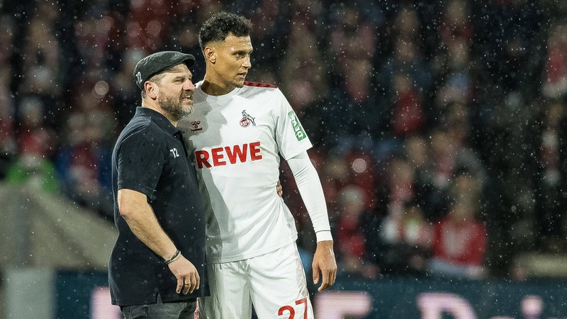 Steffen Baumgart und Davie Selke stehen zu ihrer Zeit beim 1. FC Köln nebeneinander im Stadion.