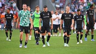 Werder-Spieler stehen nach dem Remis in Augsburg erschöpft und mit leeren Mienen auf dem Platz.